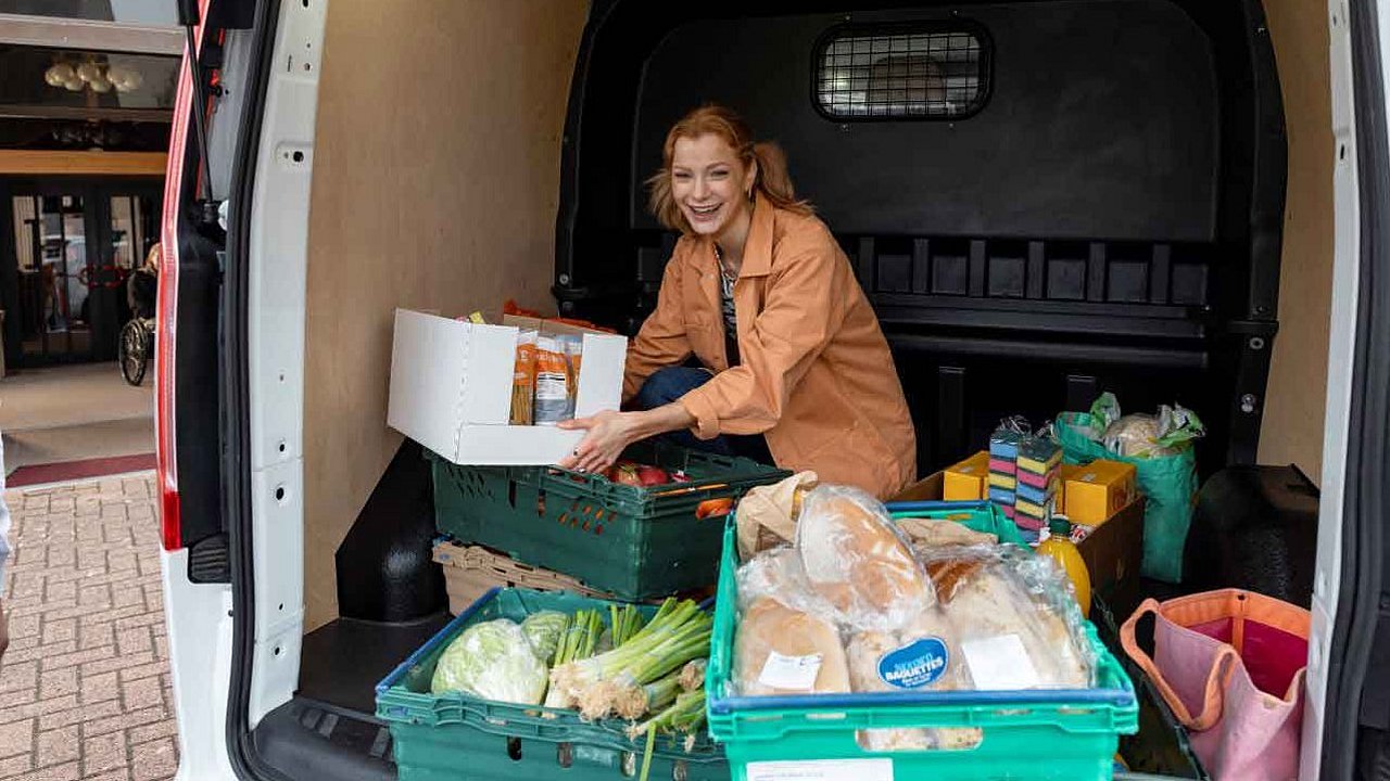Eine Frau sortiert in einem Kofferraum Kisten mit Lebensmittelspenden