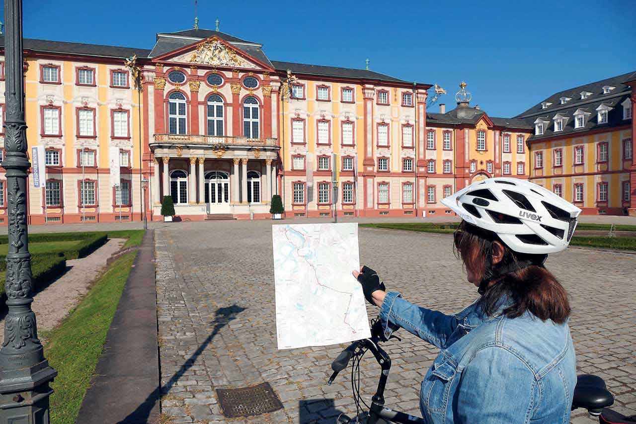 Ute Lang mit ihrem Rad vor dem Barockschloss in Bruchsal