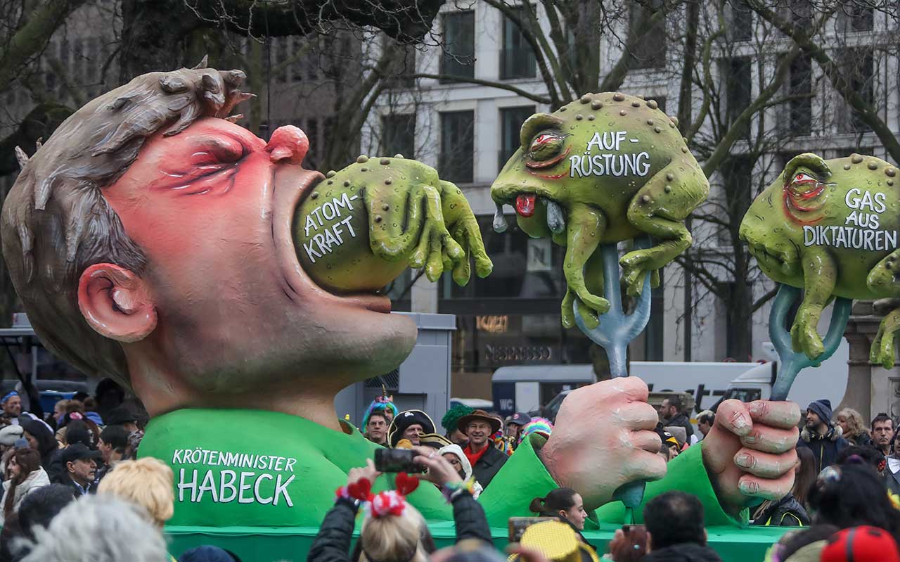 Motivwagen beim Düsseldorfer Rosenmontagszug 2023. Er zeigt Robert Habeck als "Krötenminister", der die Kröten „Atomkraft“, „Aufrüstung“ und „Gas aus Diktaturen“ schluckt.