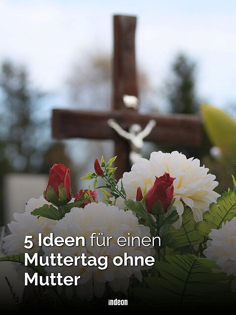 Blumenschmcuk vor einem Grabkreuz mit einer weißen Jesus-Figur. Text: 5 Ideen für einen Muttertag ohne Mutter