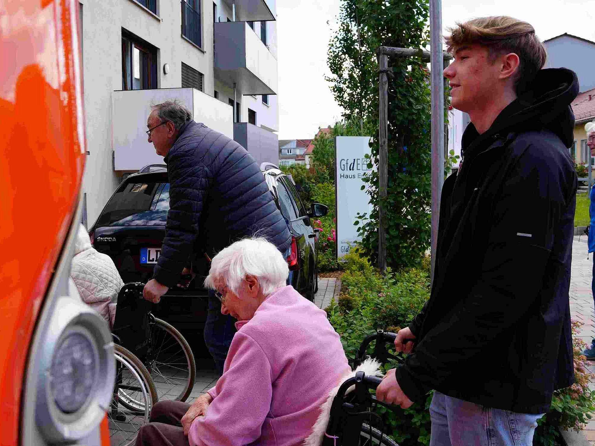 Reporter wartet mit Frau M. aus dem Haus Emmaus vor Bus Rampe