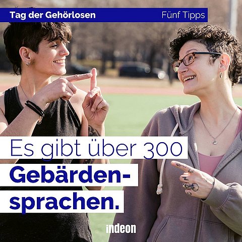 Zwei junge Frauen unterhalten sich gut gelaunt in Gebärdensprache.