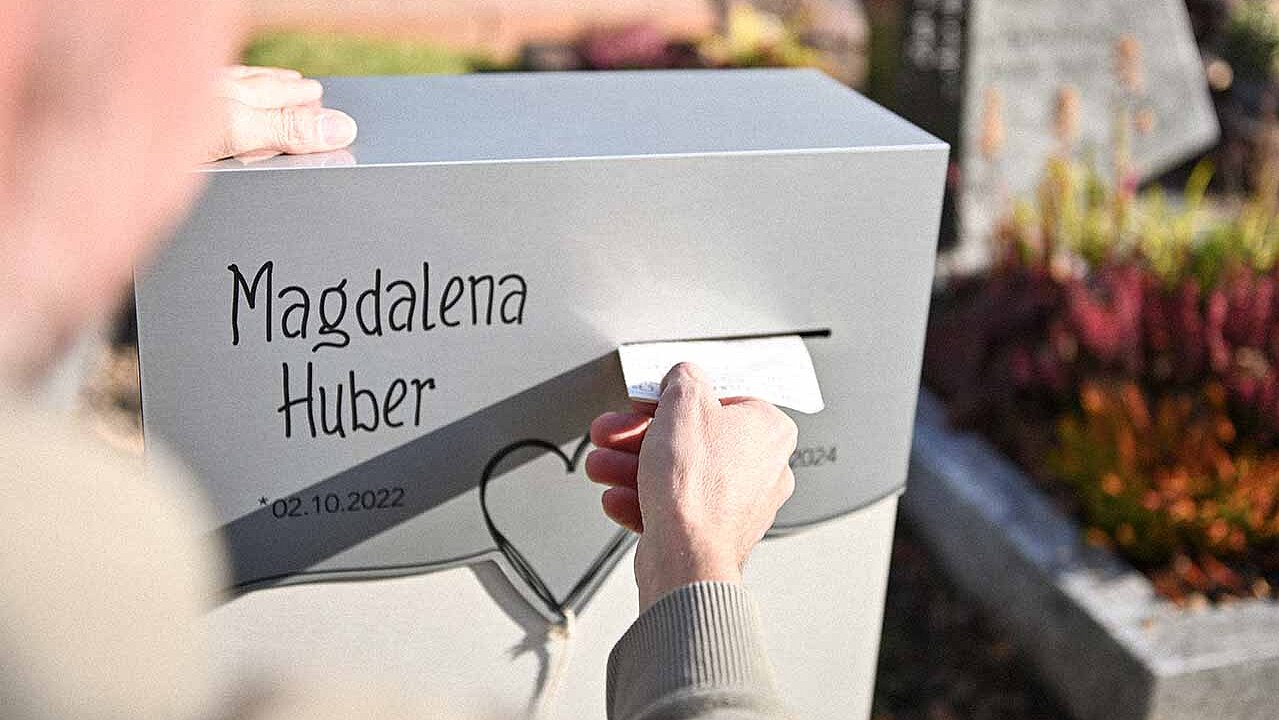 Ein Mann wirft eine Mitteilung in einen Grabstein