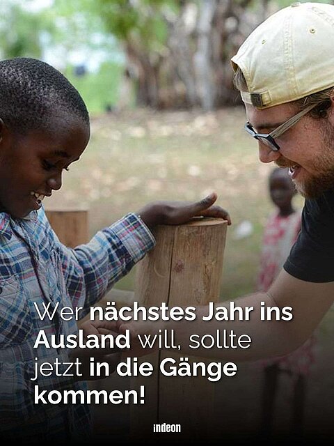 Ein junger weißer Mann unterhält sich mit einem schwarzen Kind.