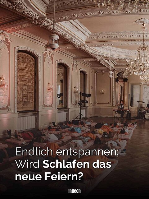 Ein prunkvoller Ballsaal mit vielen gemütlichen Matratzen. Im Hintergrund eine Band.