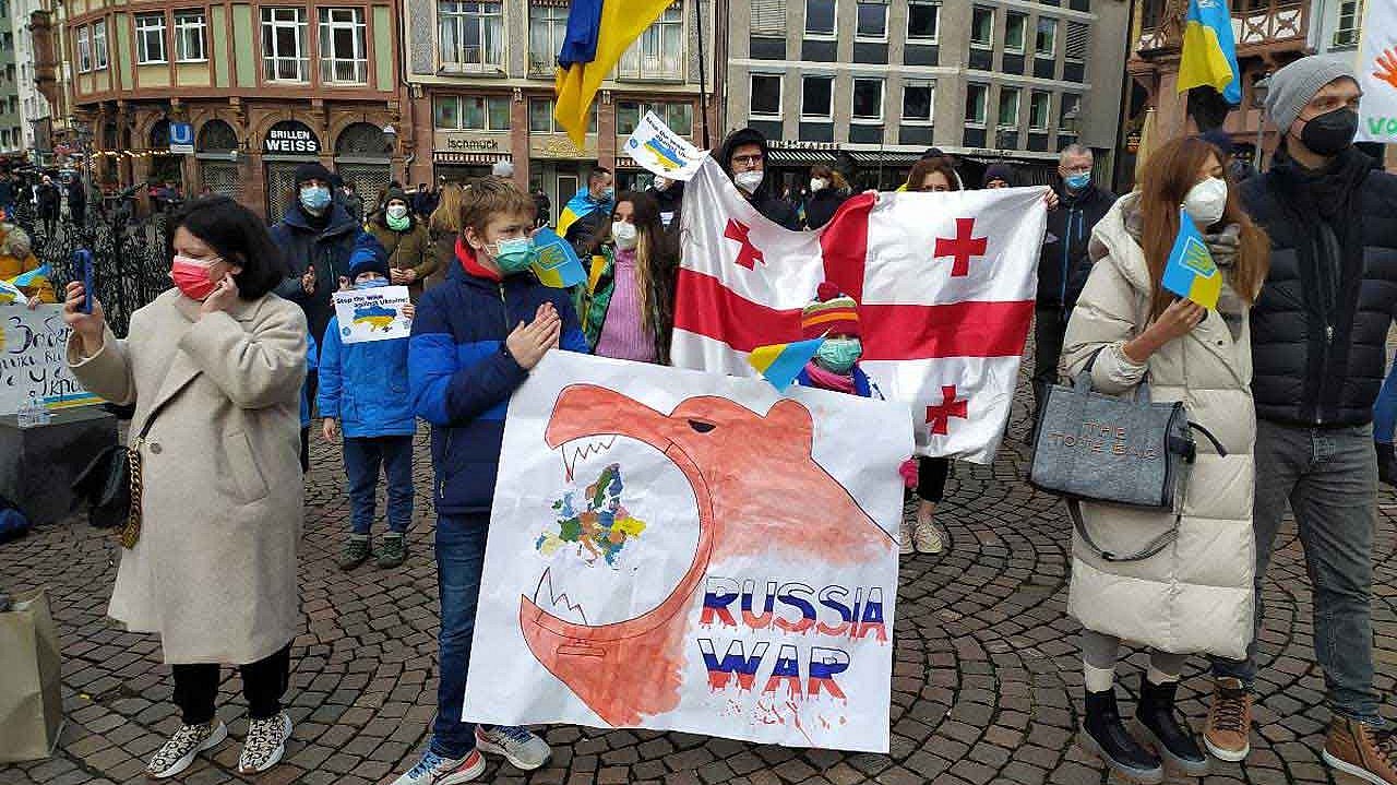 Auf der Demo fordern die Menschen ein Ende von Putins "Militae​raufmarsch" und die Lieferung von Verteidigungswaffen durch befreundete Staaten.