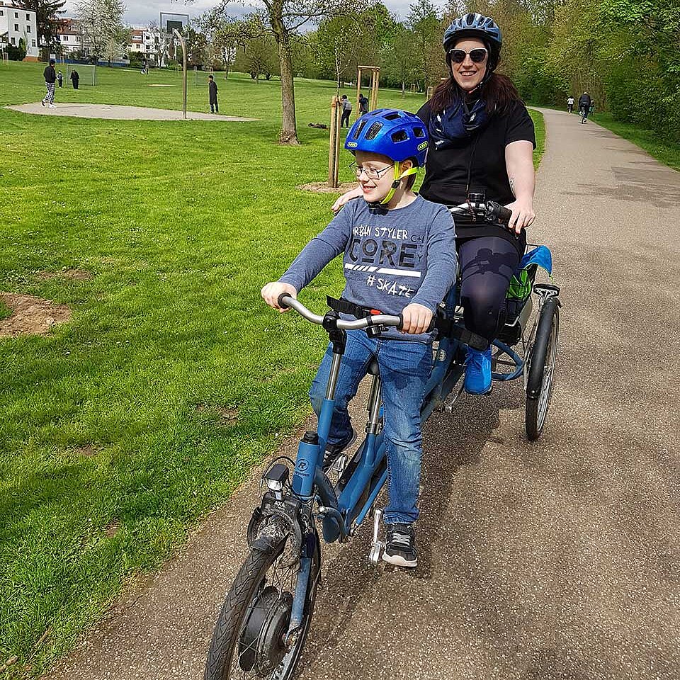 Lukas und Mama Lisa auf dem Therapietandem im Park