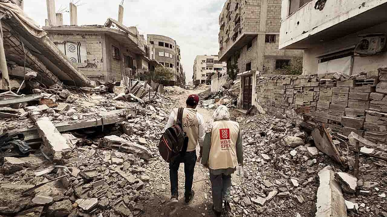 Zwei Mitarbeiter von HEKS gehen durch den zerstörten Gazastreifen