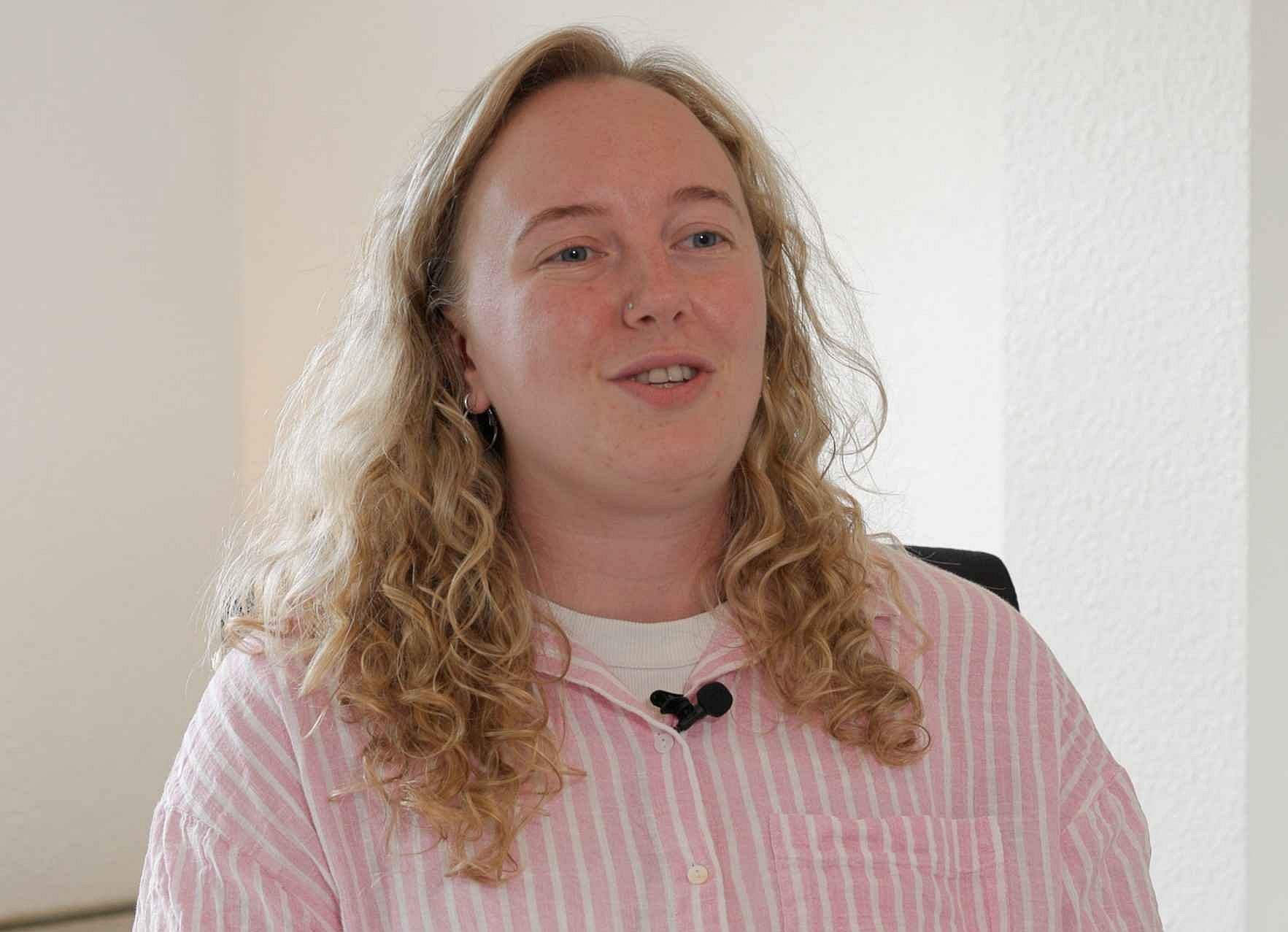 Nina Wöllert ist die pädagogische Leitung der CFEE. Sie sitzt auf einem Stuhl und unterhält sich