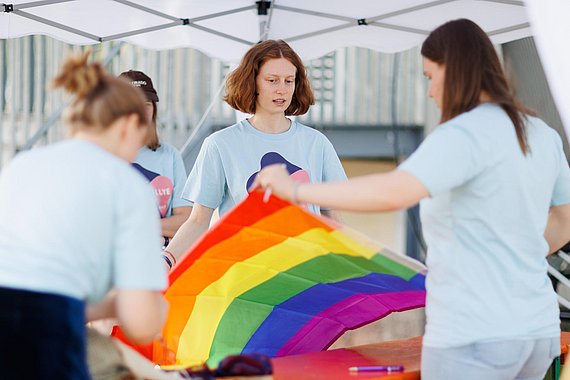 Jugendliche entfalten die Regenbogenfahne