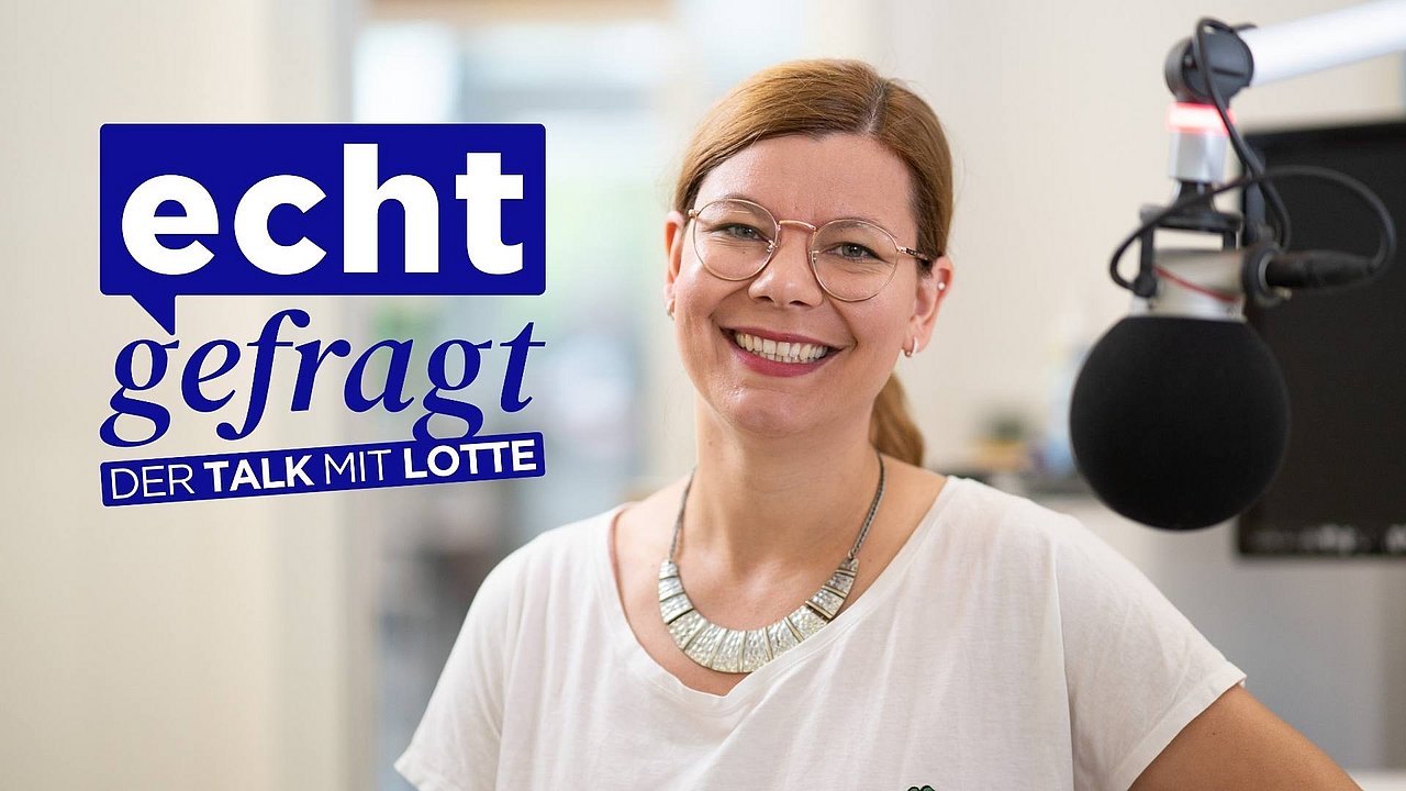 Im Vordergrund, unscharfer Pferdeschwanz, mit rosa Haargummi, im Hintergrund Host Charlotte Mattes, lächelt und gestikuliert im Aufnahmestudio. Daneben Logo: Echt gefragt - der Talk mit Lotte.
