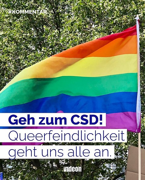 Eine Regenbogenflagge. Text: "Geh zum CSD! Queerfeindlichkeit geht uns alle an