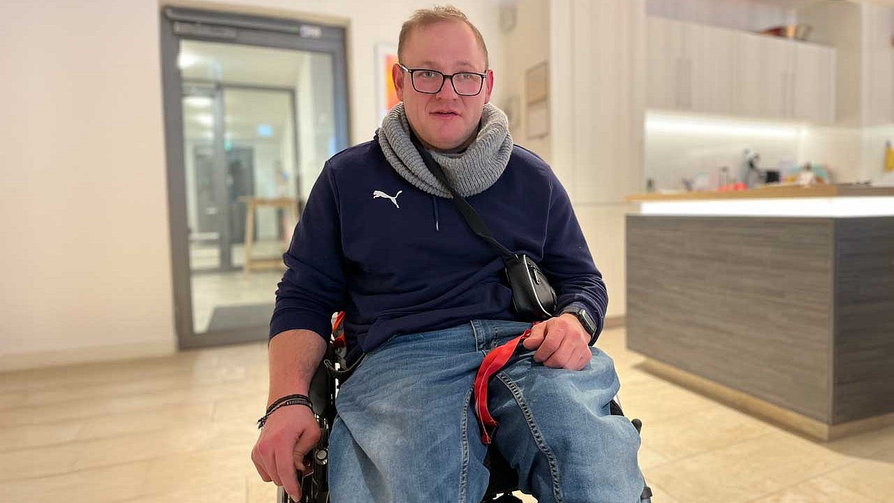 Kristjan Zweigert sitzt in seinem Rollstuhl im Flur