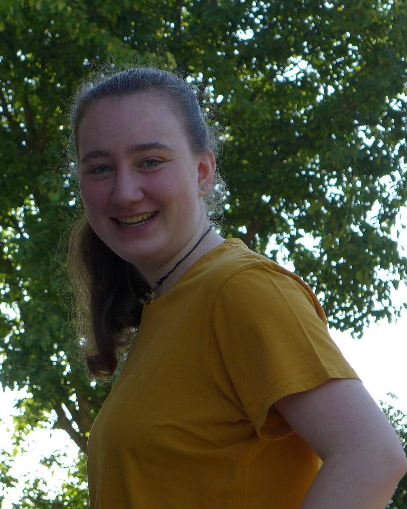 Jasmin im gelben Shirt lächelt