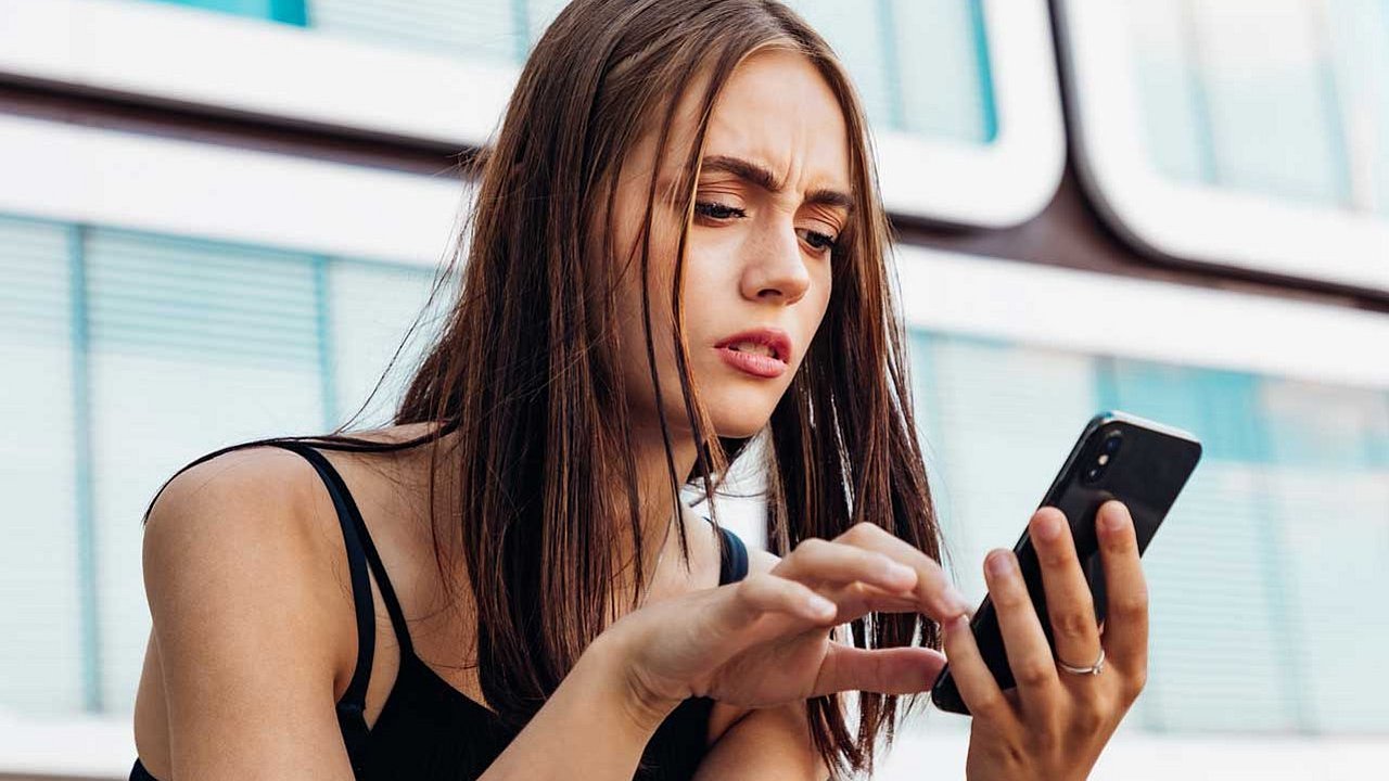 Eine besorgte Frau überprüft Nachrichten auf ihrem Smartphone