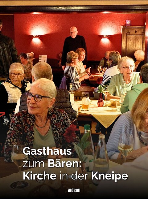 in einem vollen Gastrausm sitzen viele menschen an runden tischen. Sie sehen zufrieden aus, vor ihnen stehen teller und Gläser mit Getränken. 