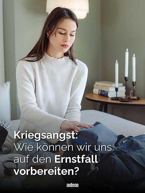 Nachdenkliche junge Frau packt eine Notfalltasche, Text: „Kriegsangst: Wie können wir uns auf den Ernstfall vorbereiten?“
