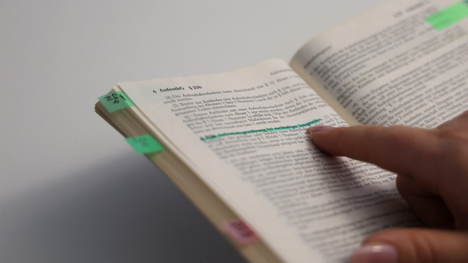 Das aufgeschlagene Aufenthaltsgesetz. Im Text mit grünem Highlighter markiert: Paragraph 25b: Aufenthaltsgewährung bei nachhaltiger Integration