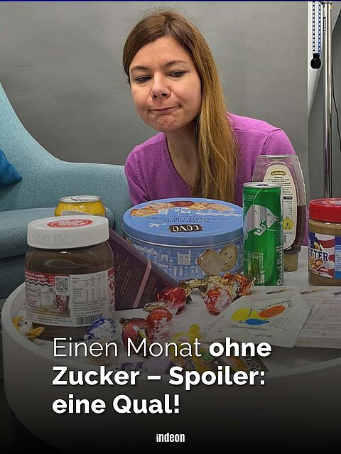 Auf dem Bild ist die Redakteurin Charlotte Mattes zu sehen. Sie sitzt im Hintergrund und blickt auf einen Tisch vor ihr. Auf diesem stehen Süßigkeiten wie Schokolade, eine Plätzchendose sowie Dosengetränke Sprite und Red Bull. Adrüber die Aufschrift: Ein Monat ohne Zucker Spoiler: Eine Qual! 