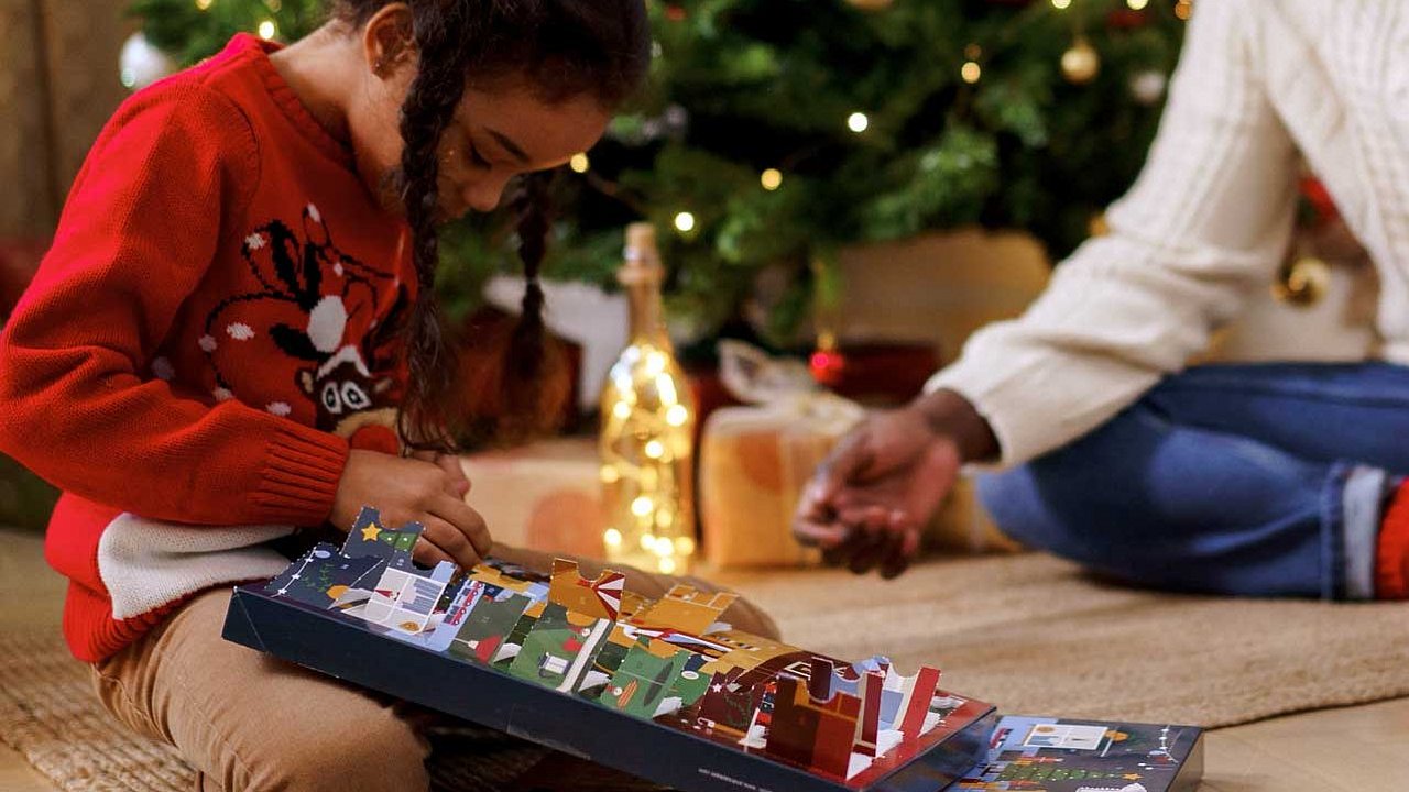 Kind öffnet letztes Türchen vom Adventskalender