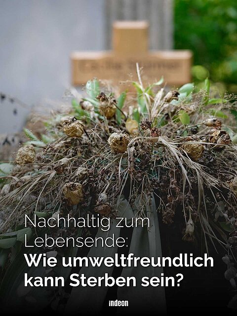 Welker Grabschmuck vor einen Holzkreuz im Hintergrund. Dazu der Text: Nachhaltig zum Lebensende: Wie umweltfreundlich kann Sterben sein?