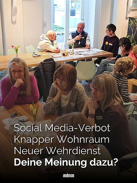 Mehrere Tische an denen mehrere Menschen sitzen. Auf den Tischen Zettel, Papiere und Getränke. Sie Diskutieren angeregt miteinander und hören aufmerksam zu wenn jemand spricht. Text: Social Media-Verbot, knapper Wohnraum, neuer Wehrdienst: deine Meinung dazu?