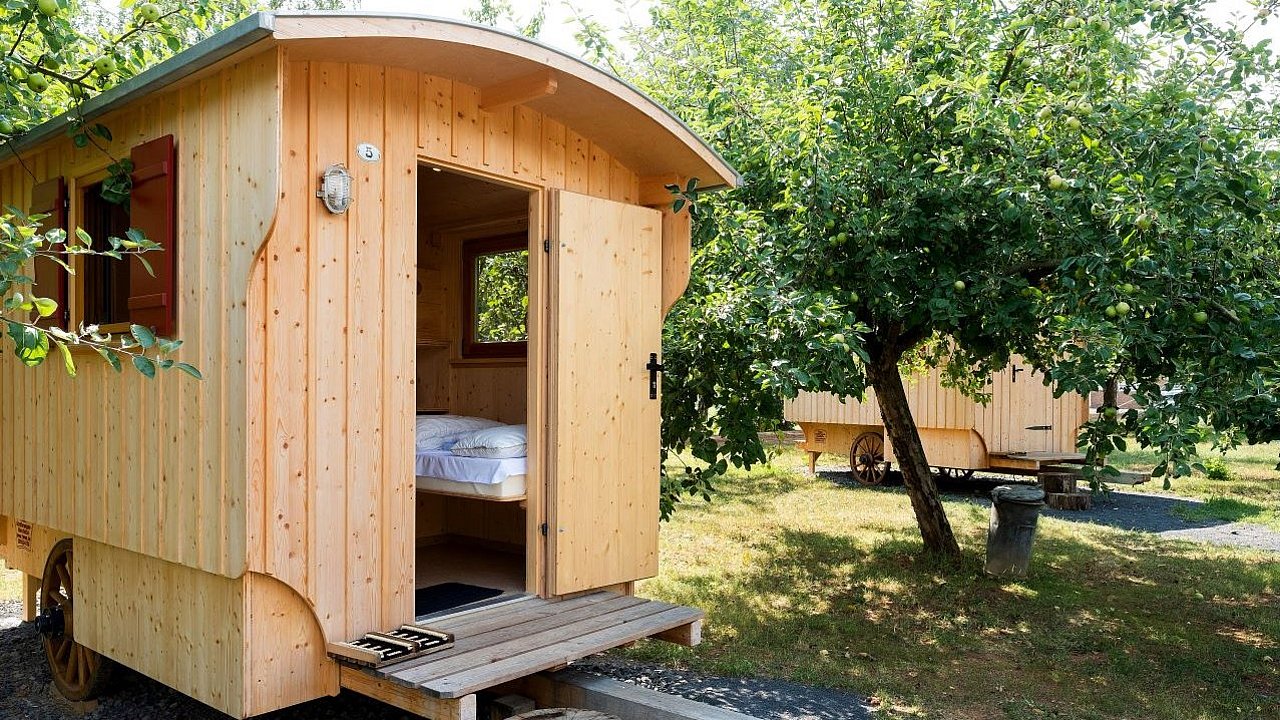 In einem Schäferwagen aus Holz mitten in einem Waldstück können Urlaub übernachten.