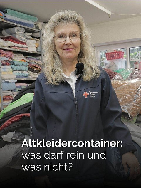 Eine Frau mit blonden lockigen Haaren und einer Jacke des Deutschen Roten Kreuzes steht in einem Second-Hand-Laden. Text: Altkleidercontainer: was darf rein und was nicht?