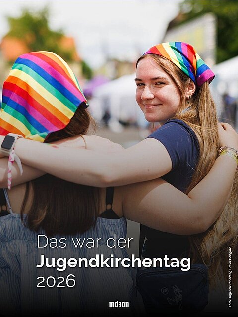 Zwei junge Frauen Arm in Arm auf dem Jugendkirchentag. Sie tragen Kopftücher in Regenbogenmuster. Text: Das war der Jugendkirchentag 2026