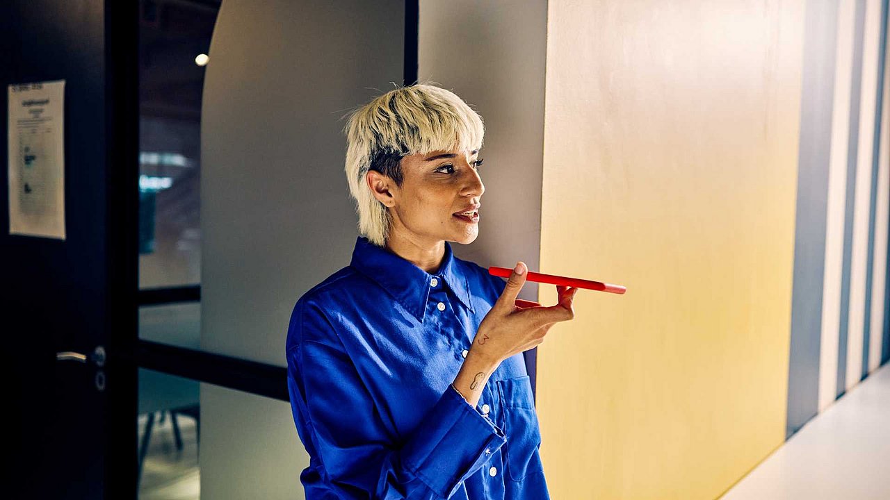 Frau am Handy redet mit KI
