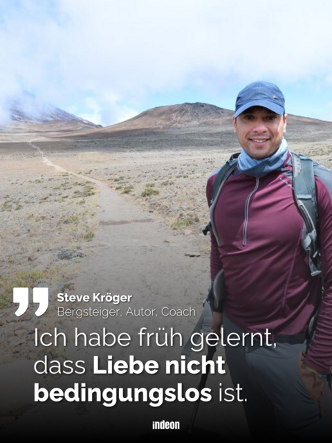 Steve Kröger in Bergsteigausrüstung, dahinter ein langer Weg und ein Berggipfel in den Wolken.
