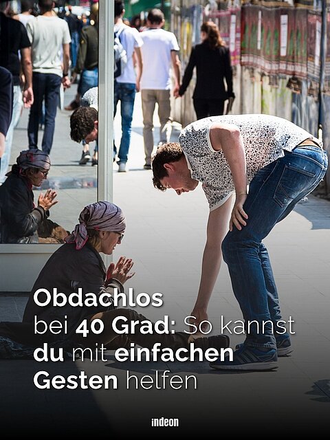 Ein Mann beugt sich in einer Fubgängerzone zu einer knienden Frau hinuter und gibt ihr geld.