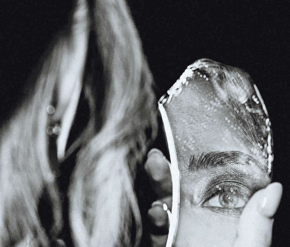 Schwarz-Weiß-Porträt der Frau und zerbrochener Selbstbildspiegel