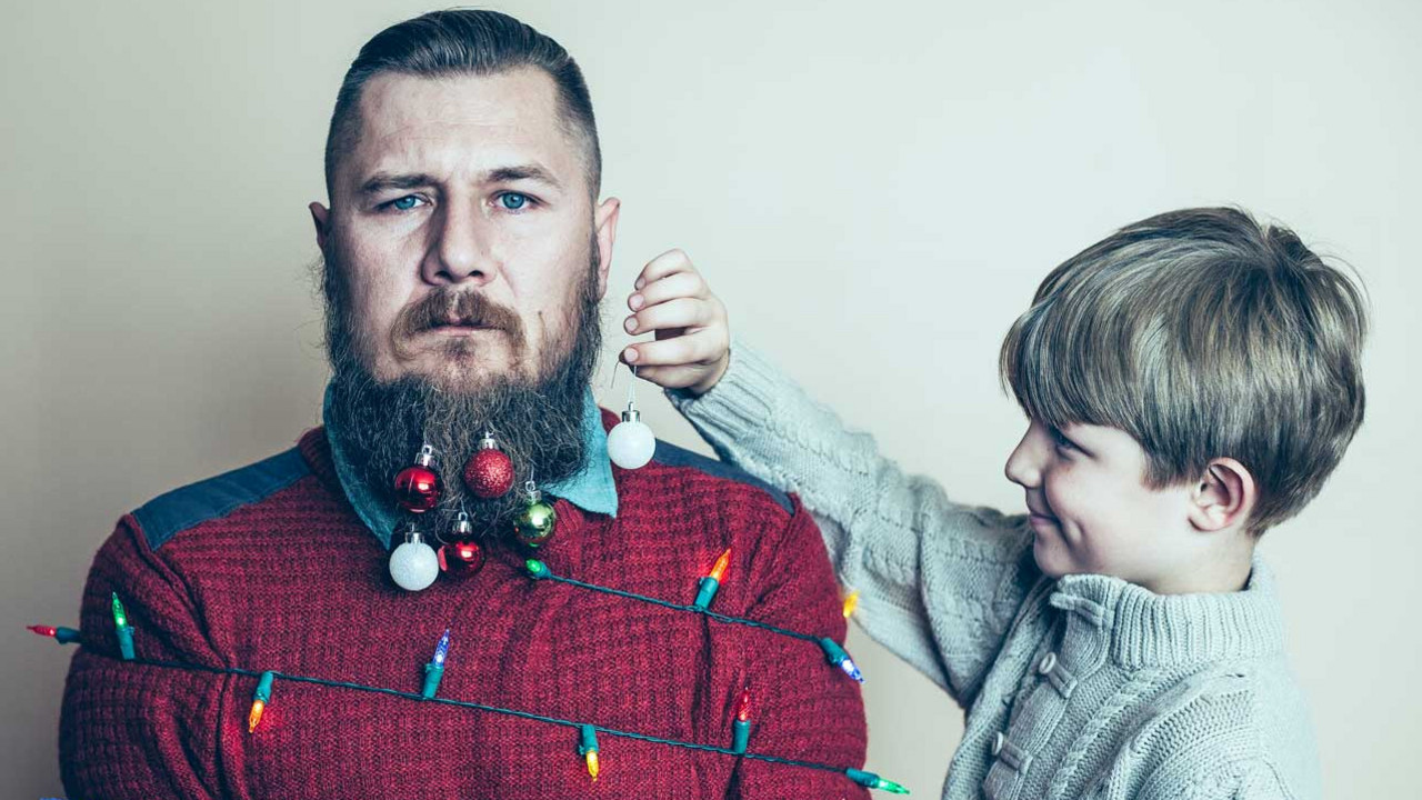 Junge dekoriert bärtigen Mann mit Weihnachtsdeko