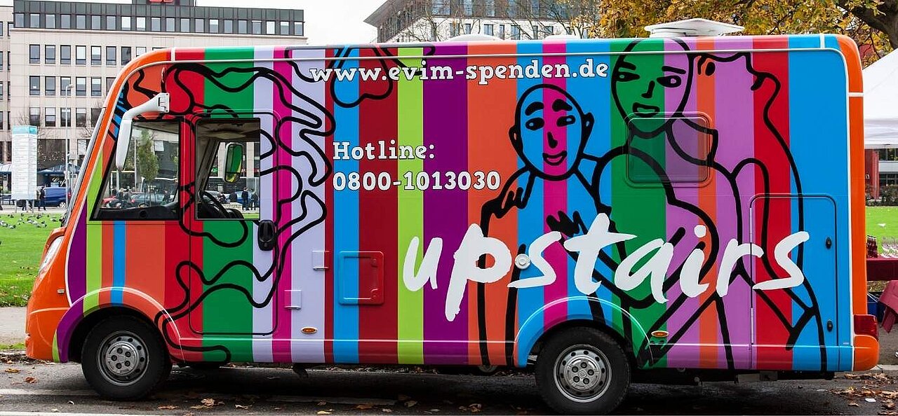 Der bunte Bus von upstairs ist von der Seite abgebildet. 
