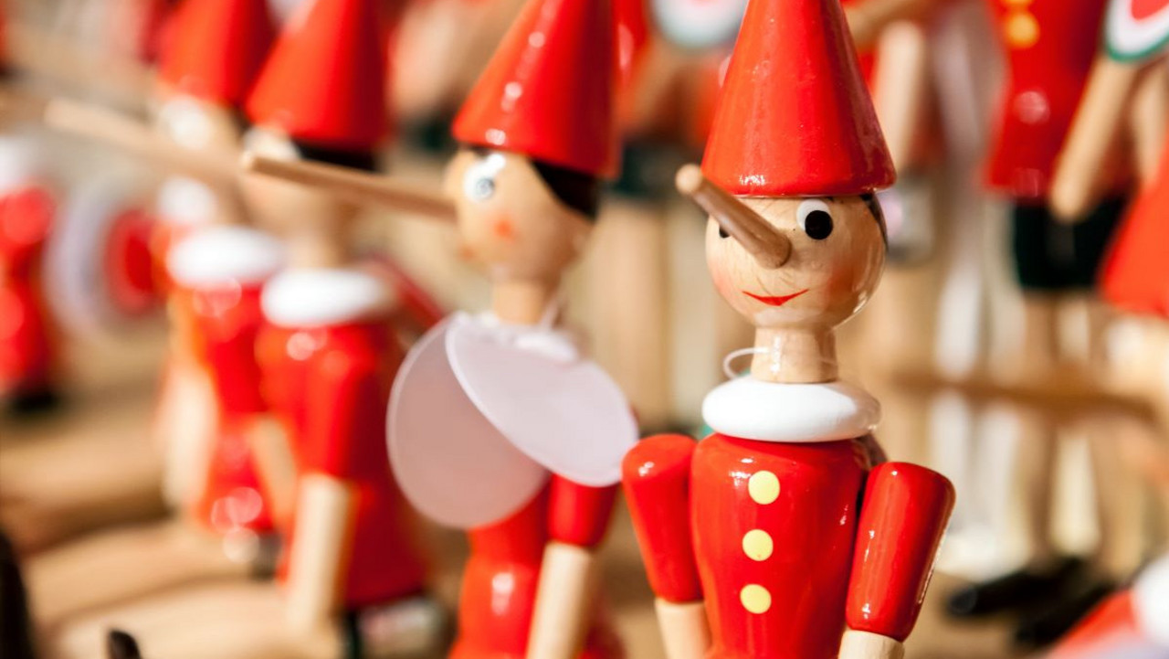 Holzfiguren mit rotem Hut und langer Nase.