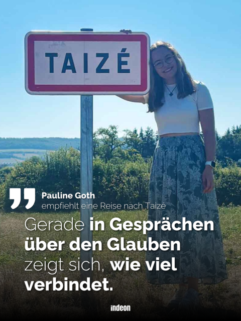 Auf dem Bild ist das weiße Ortsschild Taizé zu sehen. Dieses hat einen roten Rand. Rechts davon steht Pauline Goth. Eine junge Frau, mit offenen dunkelblonden Haaren, einem weißen Oberteil und einem langen blau gemusterten Rock.Sie lehnt sich etwas an. 