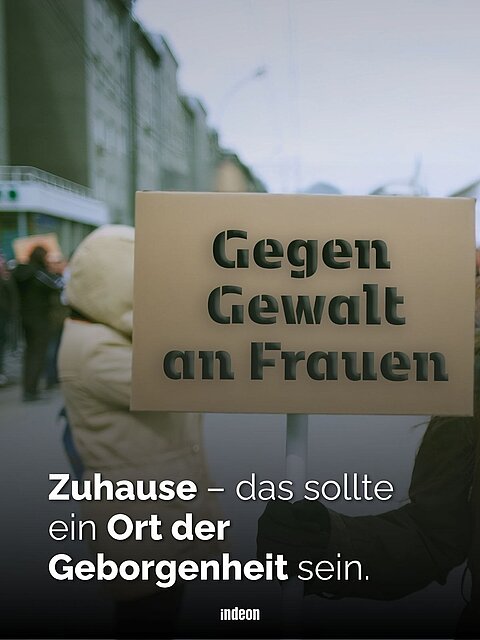Eine Person Hält ein Schild mit der Aufschrift 'Gegen Gewalt gegen Frauen'. Text: Zuhause - das sollte ein Ort der Geborgenheit sein.