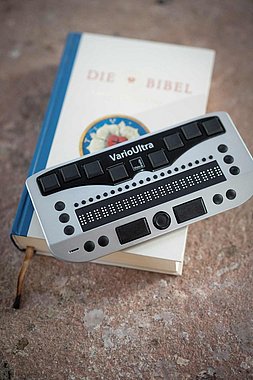 Brigitte Buchsein ertastet auf dem Lesegerät die Braille Buchstaben 