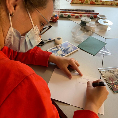 Götzenhain packt Weihnachtspakete - Frau schreibt Karte