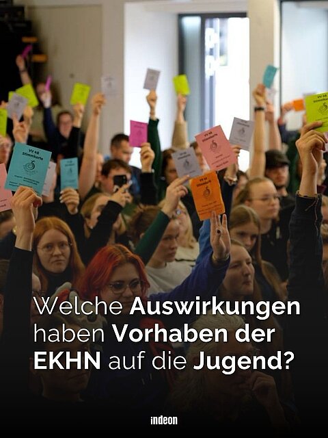 Eine Textkachel. Darauf zu sehen im Hintergrund junge Menschen, die bunte Stimmzettel in die Luft halten. Im Vordergrund steht in weißen Buchstaben  Welche Auswirkungen haben Vorhaben der EKHN auf die Jugend? 