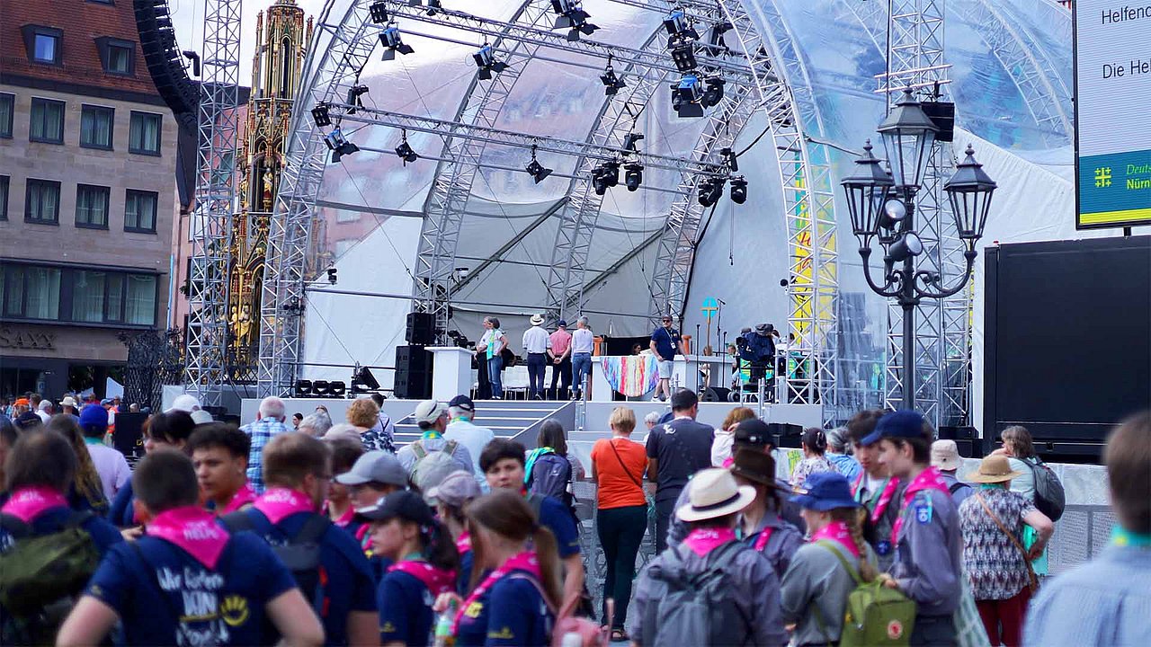 Besucher:innen des Kirchentags vor der Hauptbühne auf dem Hauptmarkt in Nürnberg