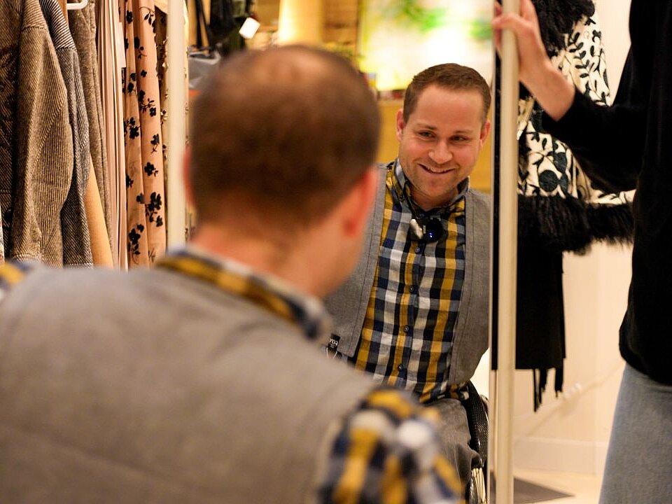 Lucas sitzt vor einem Spiegel und checkt sein Outfit