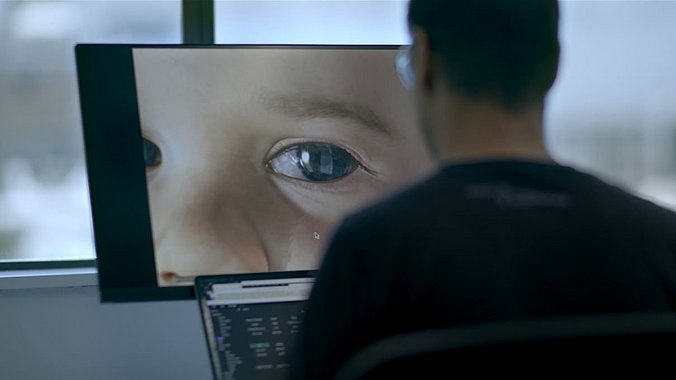 Mann schaut sich einen Avatar von einem Kind auf seinem PC an