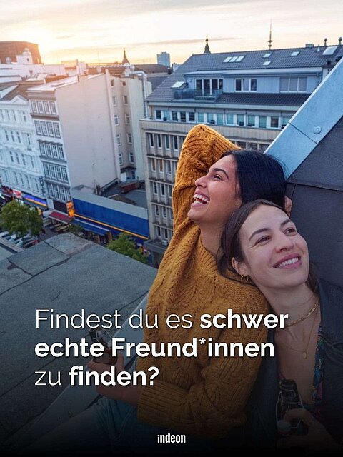 Zwei Personen auf einem Dach mit Blick auf die Straßen einer Stadt