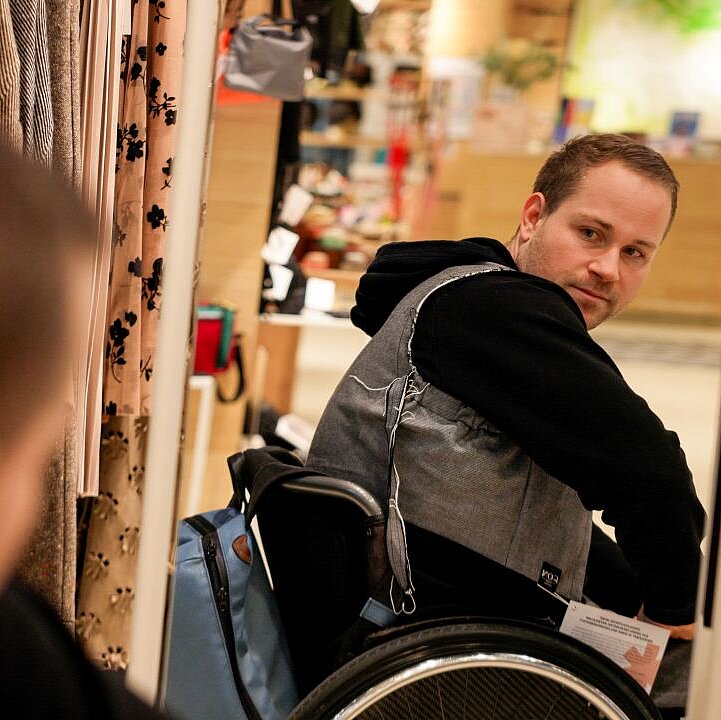 Lucas trägt eine graue Weste und einen schwarzen Hoodie von Claire