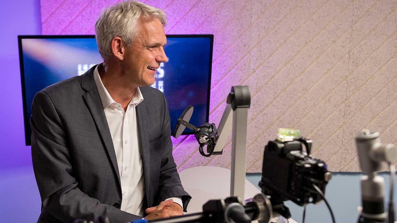 Heino Falke steht vor dem Mikro beim Podcast Hoffnungsmensch