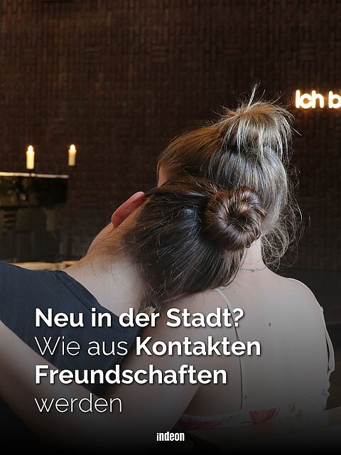 Zwei junge Frauen sitzen eng beieinander in einem Kirchenraum, Text: „Neu in der Stadt? Wie aus Kontakten Freundschaften werden“.