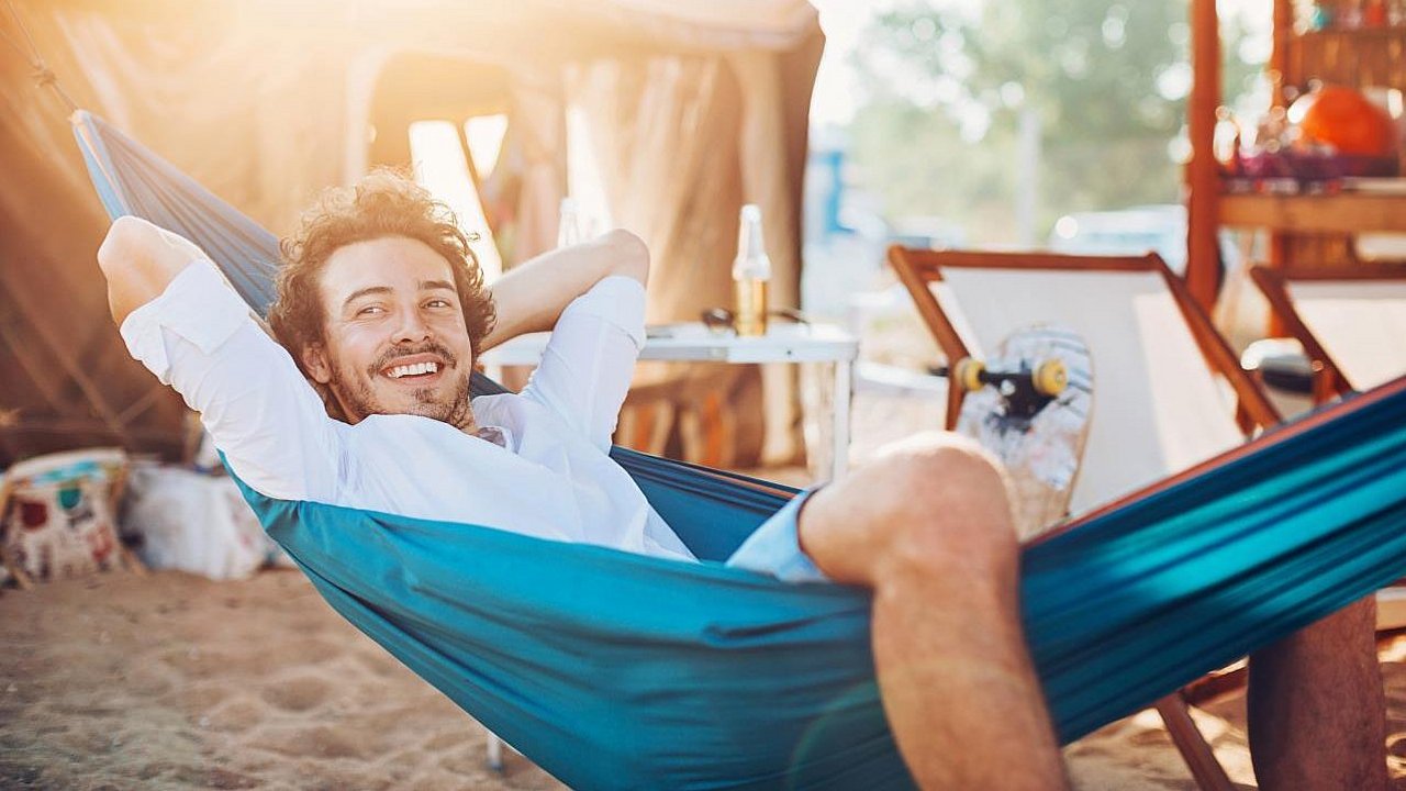 Ein junger Mann chillt in einer Hängematte