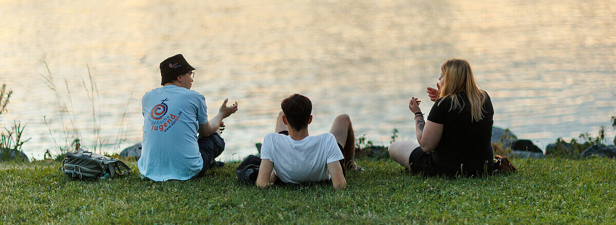 Jugendliche beim Chillen am Fluss